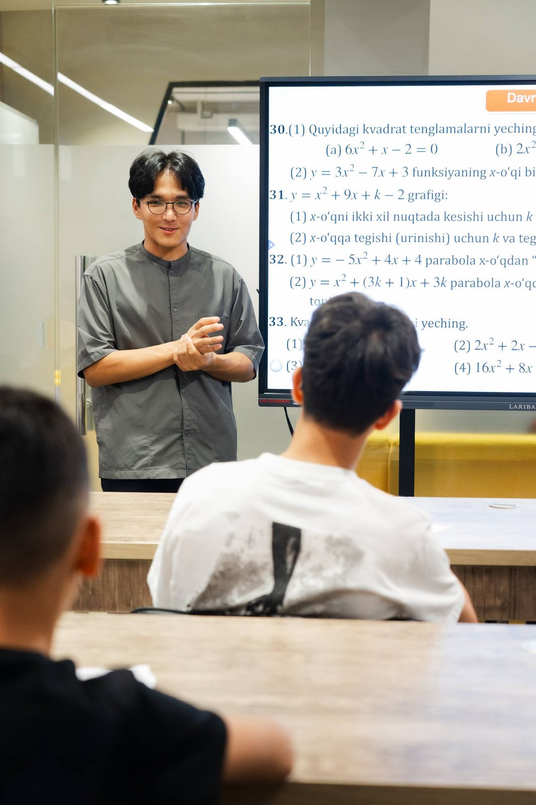 Ekranda matematika masalalari, oʻquvchilar dars tinglamoqda